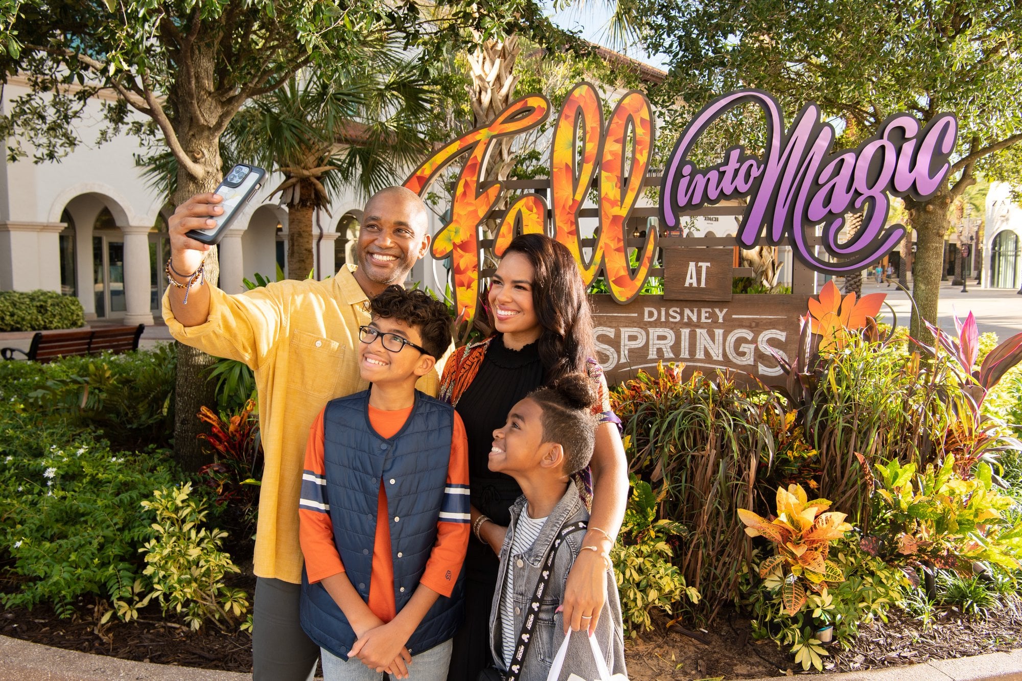 Family taking a fall selfie together at Disney Springs