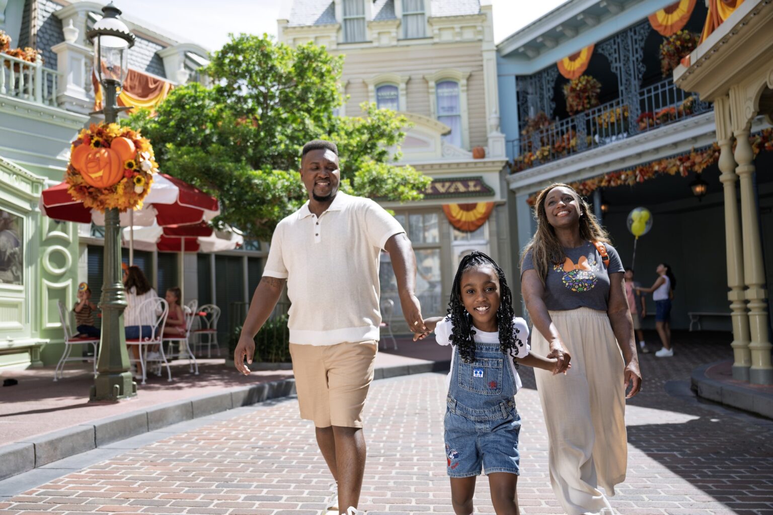 Family walking down Main Street, U.S.A. at Magic Kingdom with fall decor